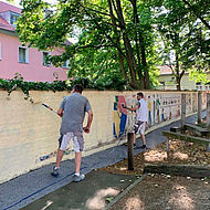 Wiesbaden Engagiert 2019 – das Team der W. Birk Baudekoration streicht die Schulhofmauer der Brüder-Grimm-Schule